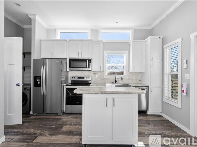 A kitchen with white cabinets and appliances.