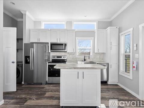 A kitchen with white cabinets and appliances.