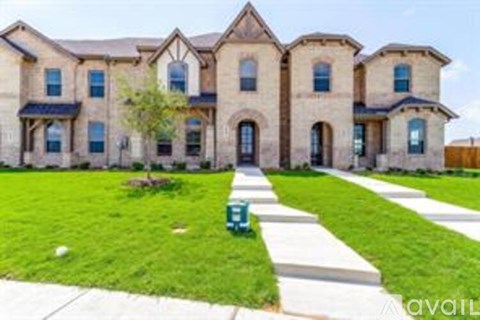 A large house with a green lawn in front.