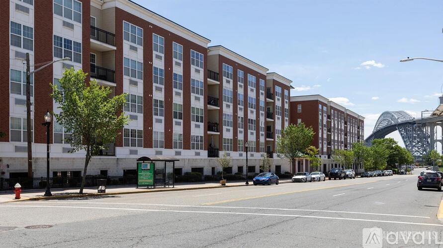 A street view of a city with apartment buildings on the left and a mountain in the background.