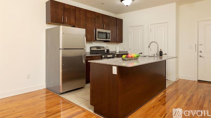 A kitchen with a refrigerator, microwave, and oven.