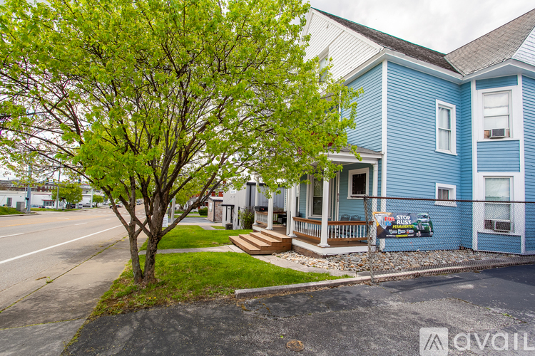 A blue house with a tree in front of it.