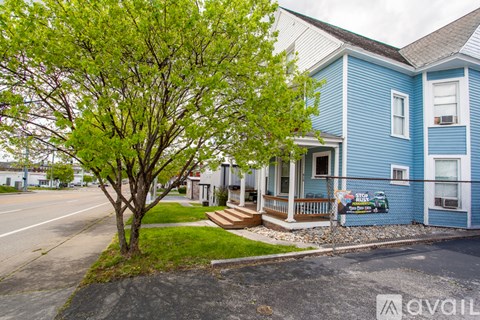 A blue house with a tree in front of it.