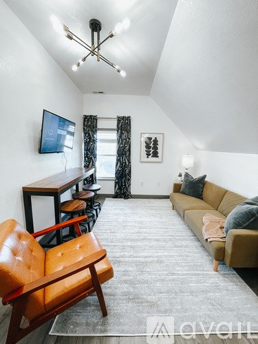A living room with a brown leather chair and a brown sofa.