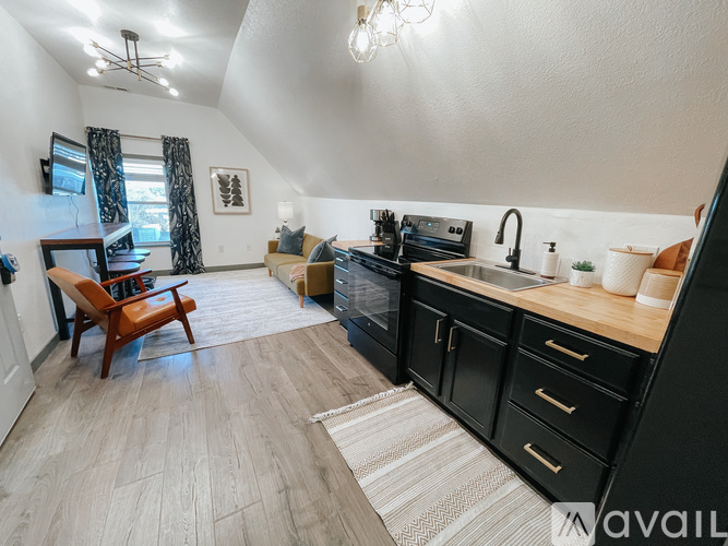 A kitchen with black cabinets and a wooden countertop.