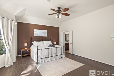 A bedroom with a large bed and a ceiling fan.