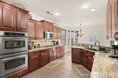 A kitchen with brown cabinets and stainless steel appliances.