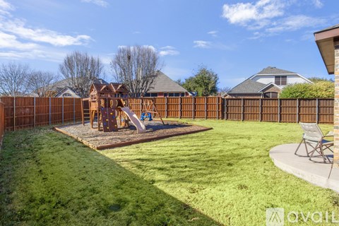 A backyard with a playground and a fence.