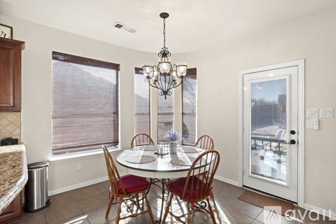 A dining room with a round table and chairs.