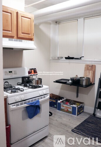 A kitchen with a white stove and wooden cabinets.