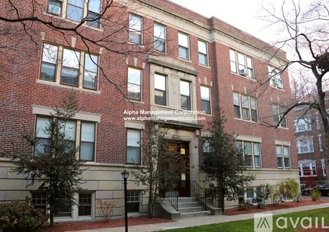 A red brick building with a black metal railing in front.