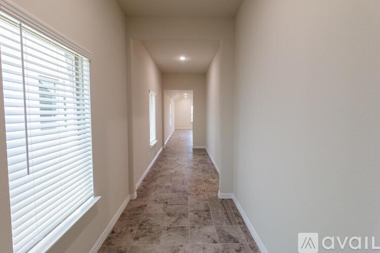 A long hallway with tiled flooring and white walls.