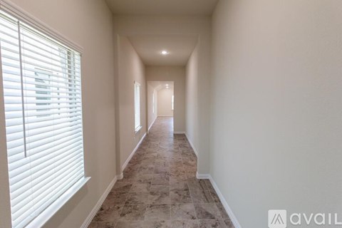 A long hallway with tiled flooring and white walls.