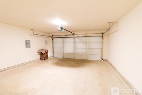 A spacious garage with a white door and a light on the ceiling.