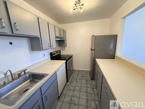 A kitchen with a sink, stove, and refrigerator.