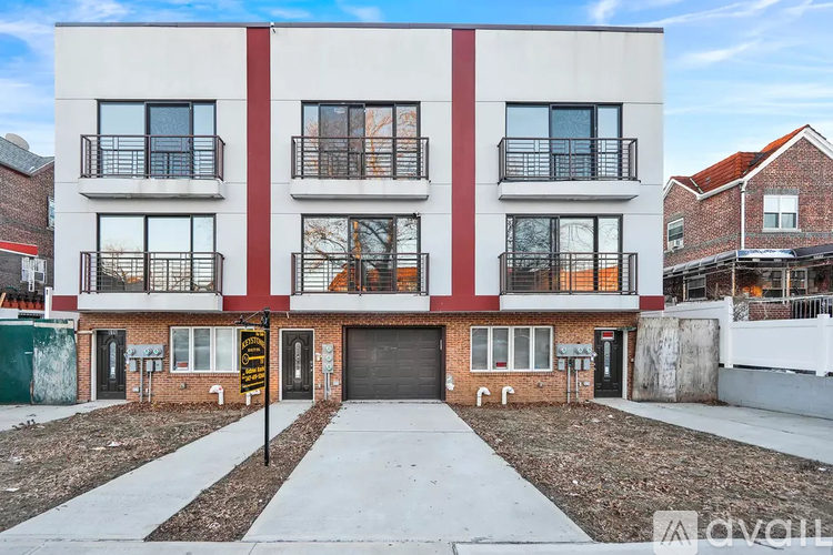 A modern two-story building with a red and white facade and black balconies.