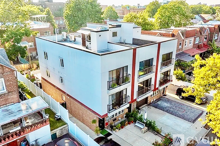 A modern apartment building with a pool in the courtyard.