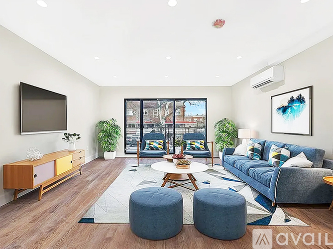 A living room with a blue couch, a wooden cabinet, and a flat screen TV.