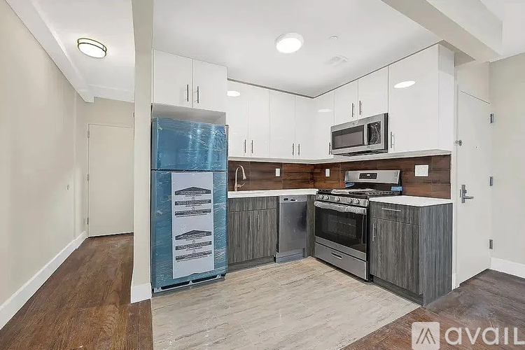 A kitchen with white cabinets and a wooden island is available for rent.