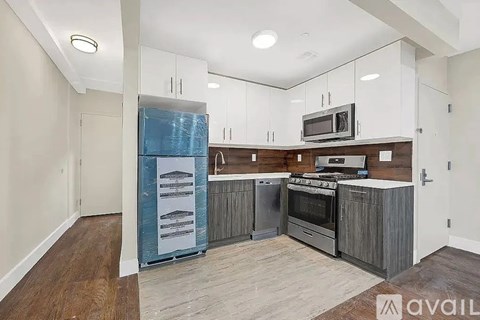A kitchen with white cabinets and a wooden island is available for rent.