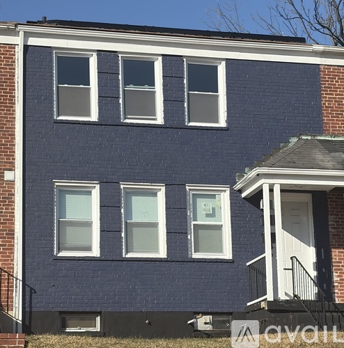 A blue brick building with white trim and windows.
