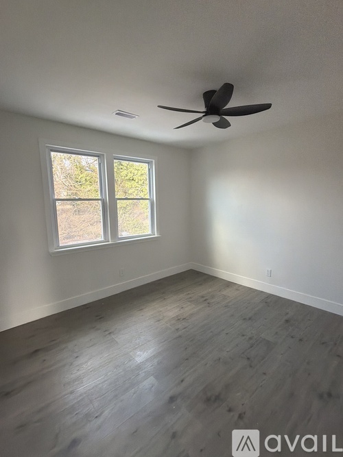 A room with a ceiling fan and a window.
