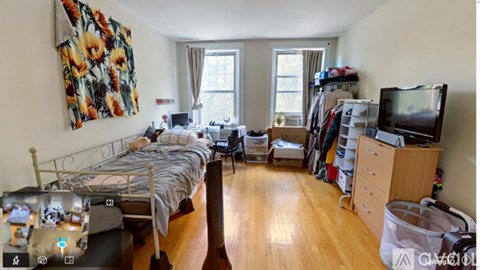 A bedroom with a bed, desk, and TV.