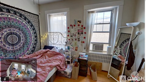 A room with a bed, a desk, and a window.