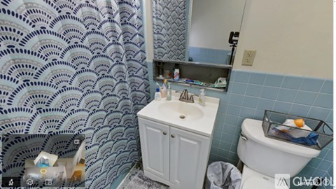 A bathroom with a white toilet and a white sink with a cabinet.