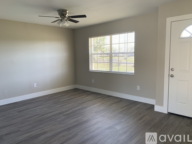 A room with a ceiling fan and a door.