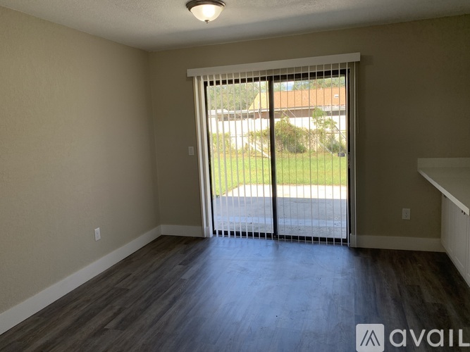 A room with a sliding glass door leading to a backyard.