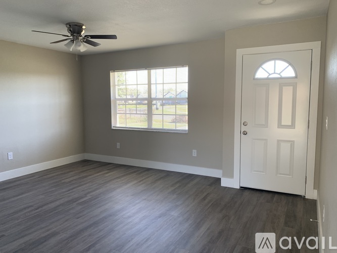 A room with a ceiling fan and a door leading to a balcony.