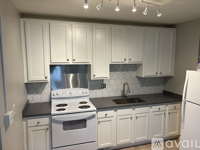 A kitchen with white cabinets and a stainless steel stove.