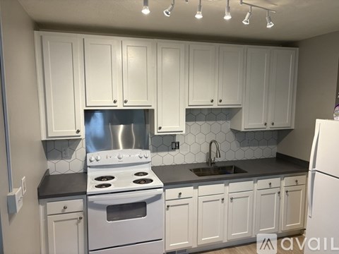 A kitchen with white cabinets and a stainless steel stove.