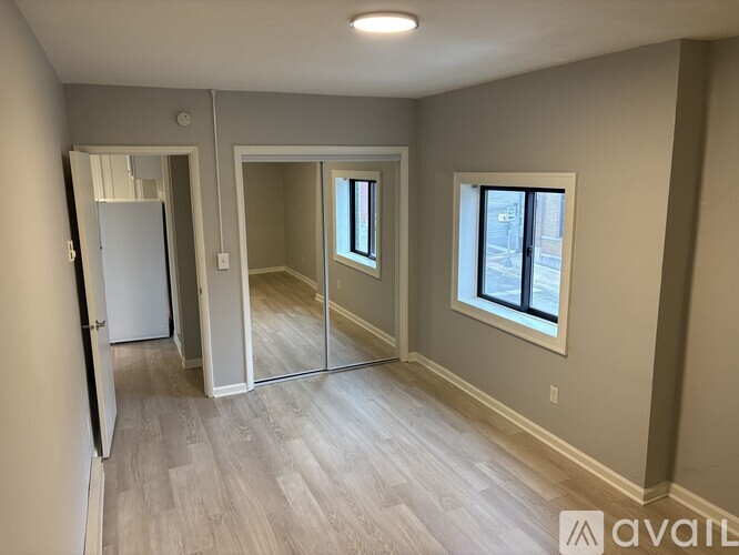 A spacious room with a white door, a window, and a sliding glass door.