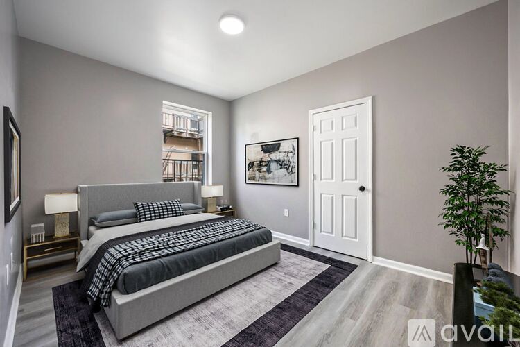 A bedroom with a large bed and a plant on the side table.