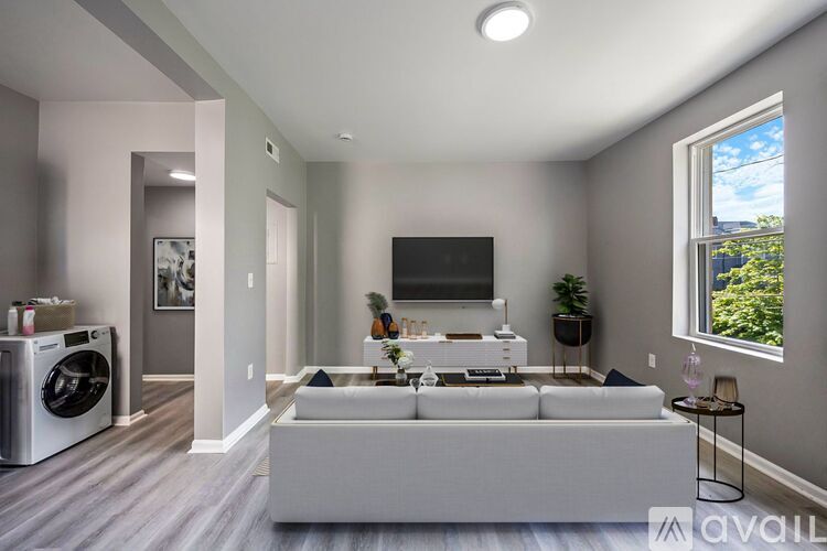A modern living room with a grey sofa and a flat screen TV.