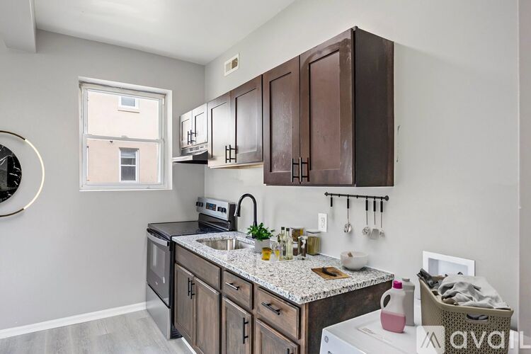 A kitchen with a white stove top oven and a window.