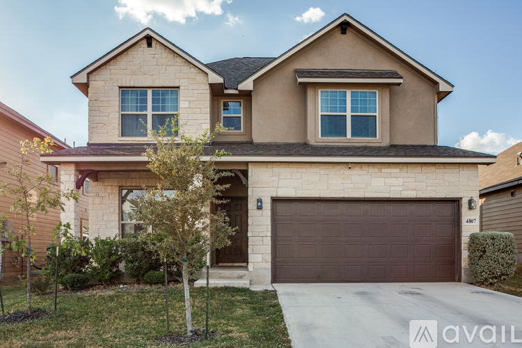A two-story house with a garage and a driveway.