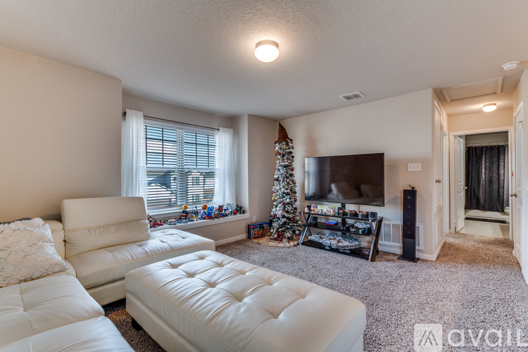 A living room with a white couch and a Christmas tree.