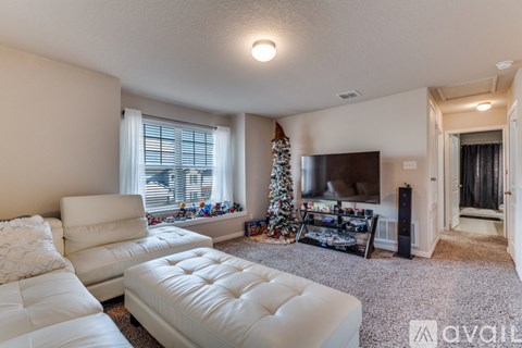 A living room with a white couch and a Christmas tree.