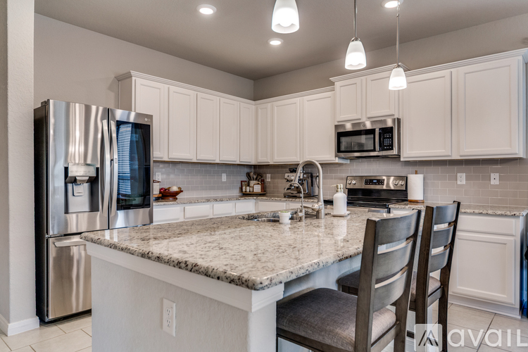 A kitchen with a granite countertop and stainless steel appliances.