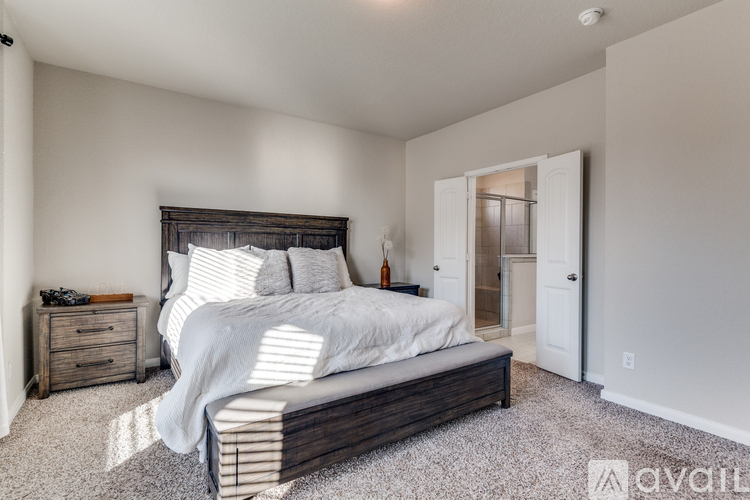 A bedroom with a large bed and a nightstand.