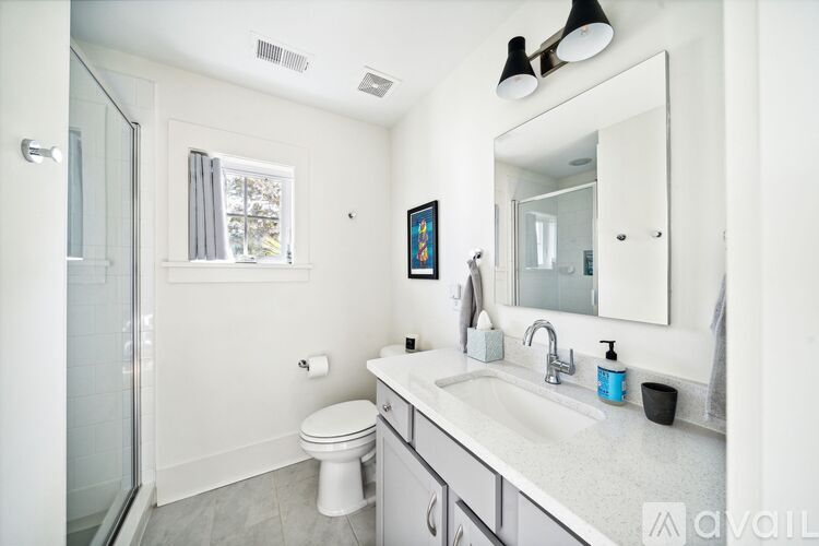 A bathroom with a white toilet, sink, and mirror.