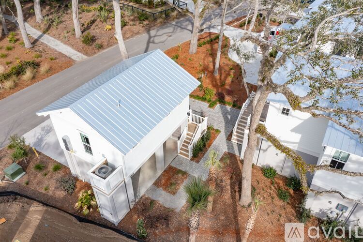 A house with a metal roof is surrounded by trees.