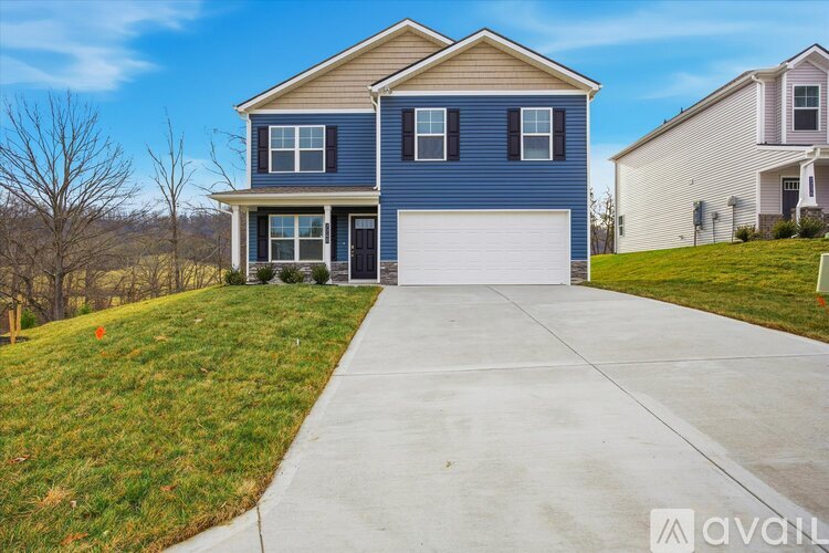 A blue house with a white garage door is for sale.