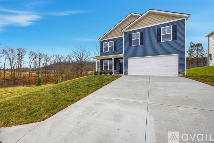 A blue house with a white garage door is available for sale.