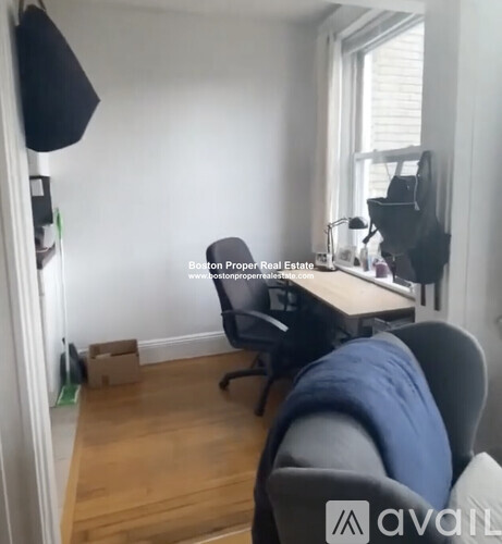 A room with a desk, chairs and a window.