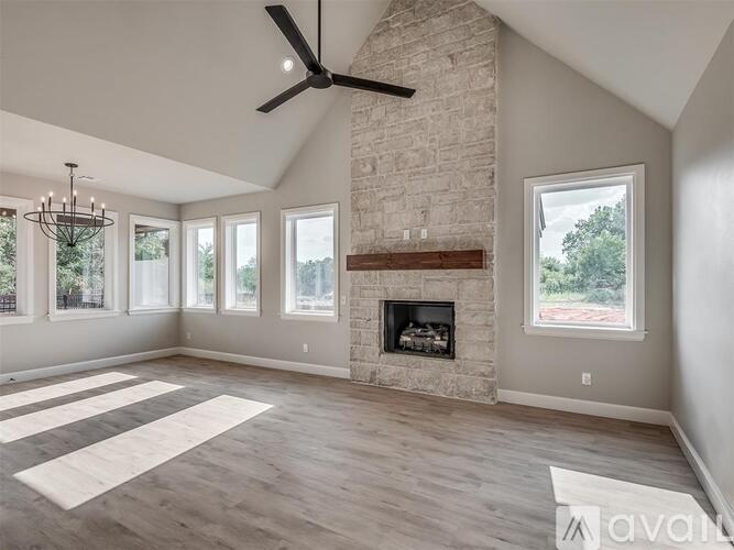 A spacious living room with a fireplace and a chandelier.