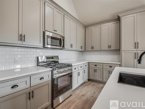 A kitchen with beige cabinets and a white countertop.